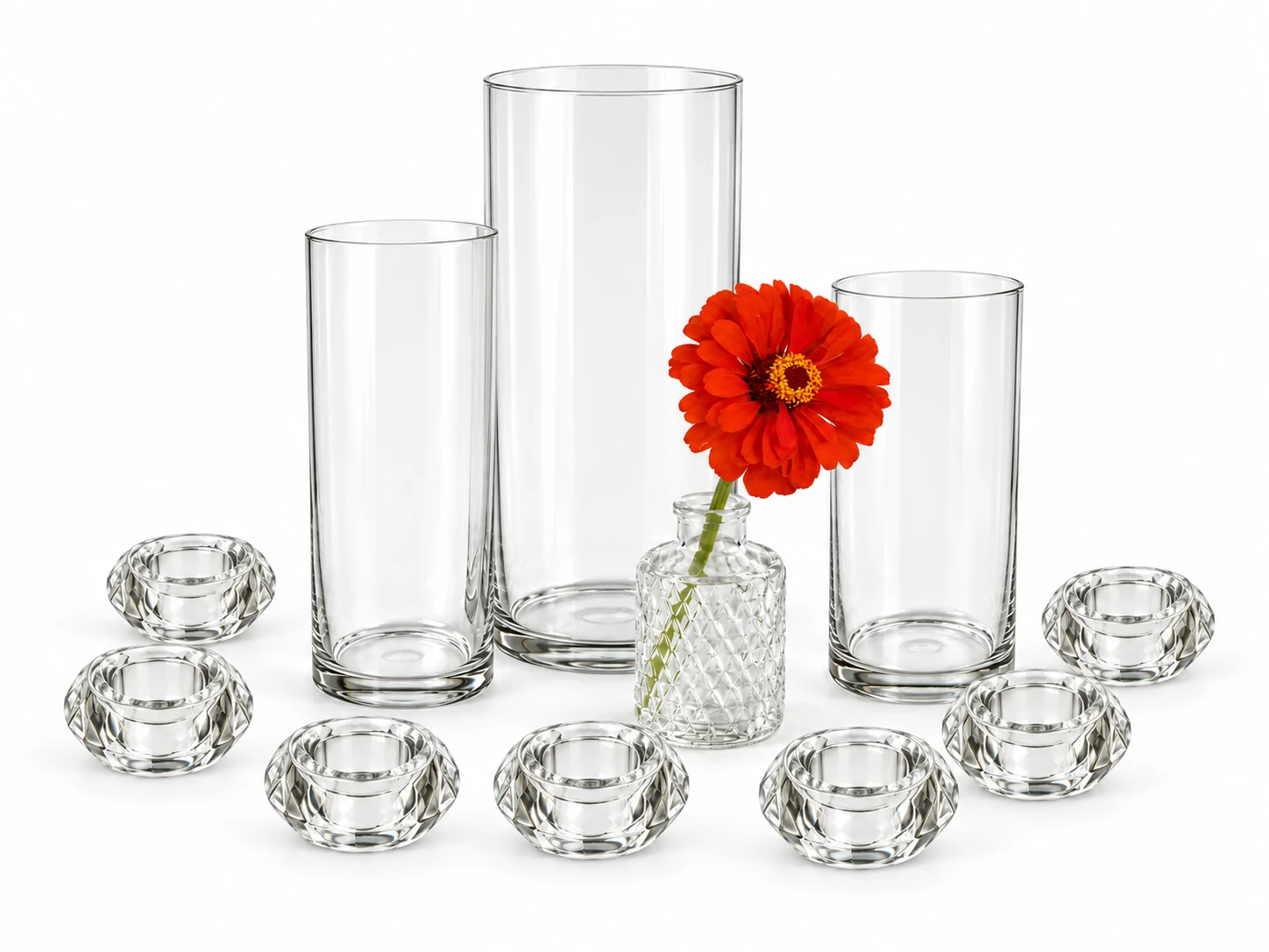 Clear hurricane vases, a bud vase with a red-orange zinnia and faceted glass votive holders together