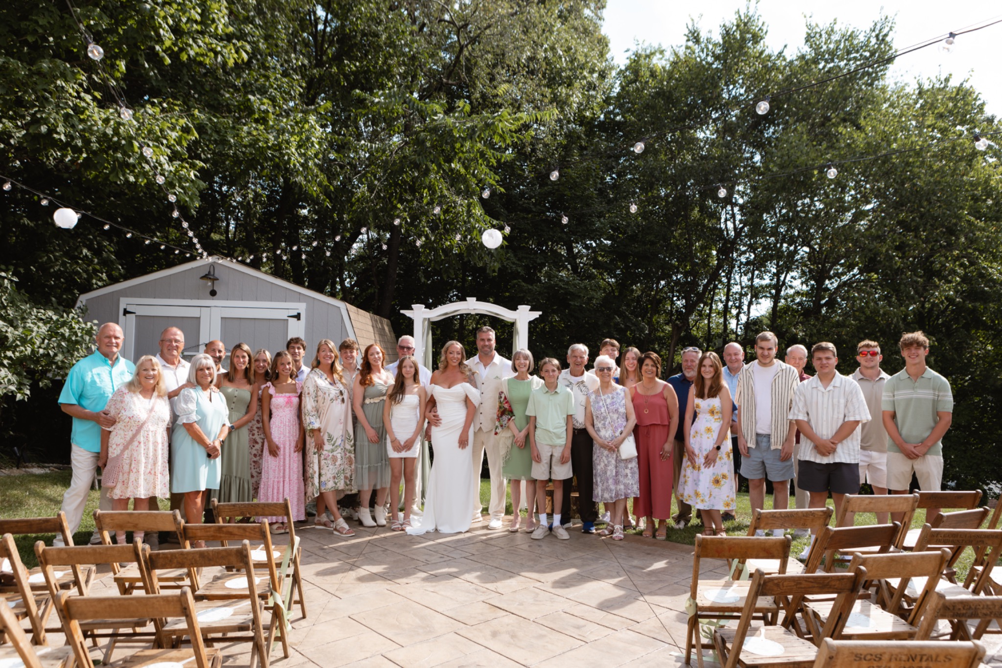 Jessie and Tom surrounded by guests after their backyard wedding ceremony