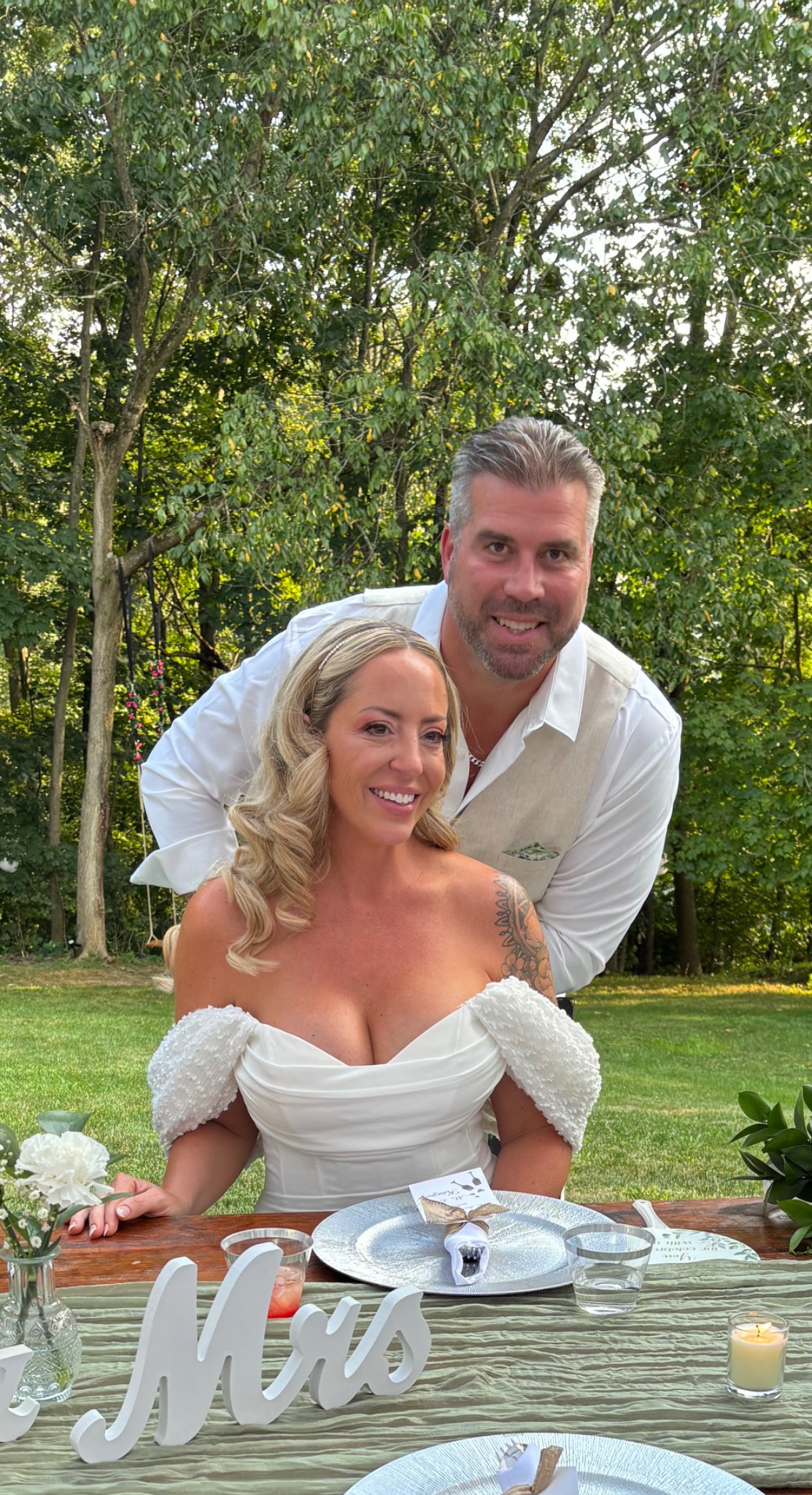 Jessie and Tom seated together at their backyard wedding